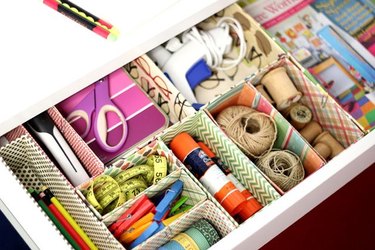 Image of a craft drawer subdivided with small, brightly decorated boxes for space-efficient storage.