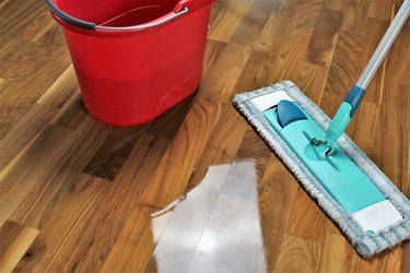 High Angle View Of Cleaning Equipments On Hardwood Floor