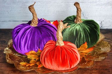 Jewel-toned velvet pumpkins on a gold plate