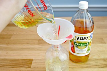 An image of apple cider vinegar being poured into a jug.