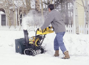 Man clearing sidewalk with snow blower