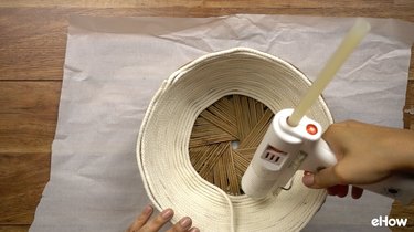 Gluing rope onto basket for DIY desert-style baskets.