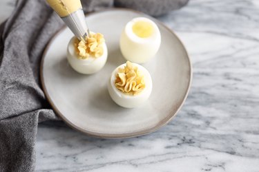 Piping egg yolk mixture into egg whites