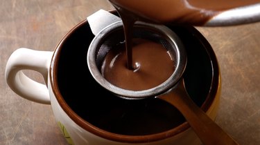 Straining low-carb, drinking chocolate into a mug to serve.
