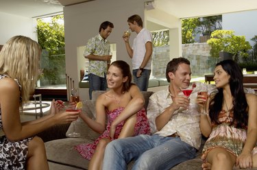 Group of people socializing indoors, holding drinks