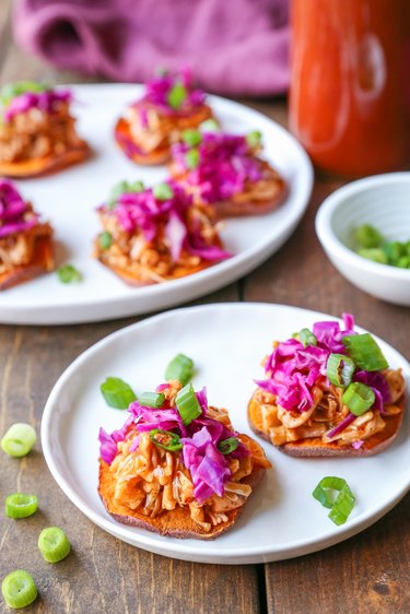 Two plates of barbecue jackfruit bites on sweet potato chips