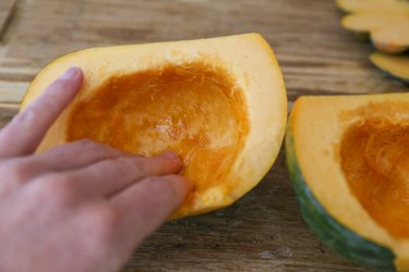 olive oil being rubbed into acorn squash