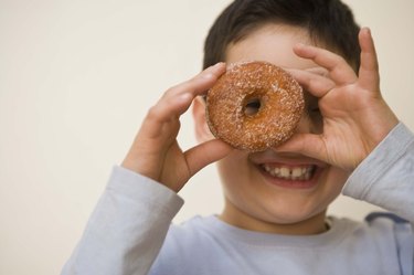 Boy looking through hole of doughnut