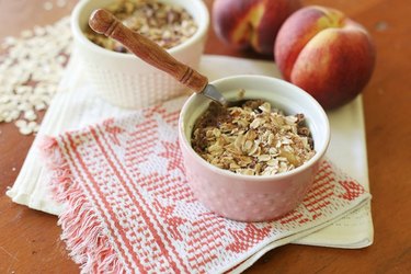 Two peach crisps in white ramekins.